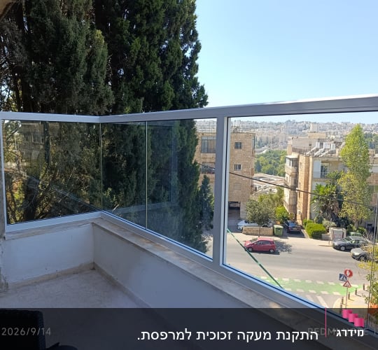 מעקה אלומיניום וזכוכית מותקן על דופן מרפסת בדירה